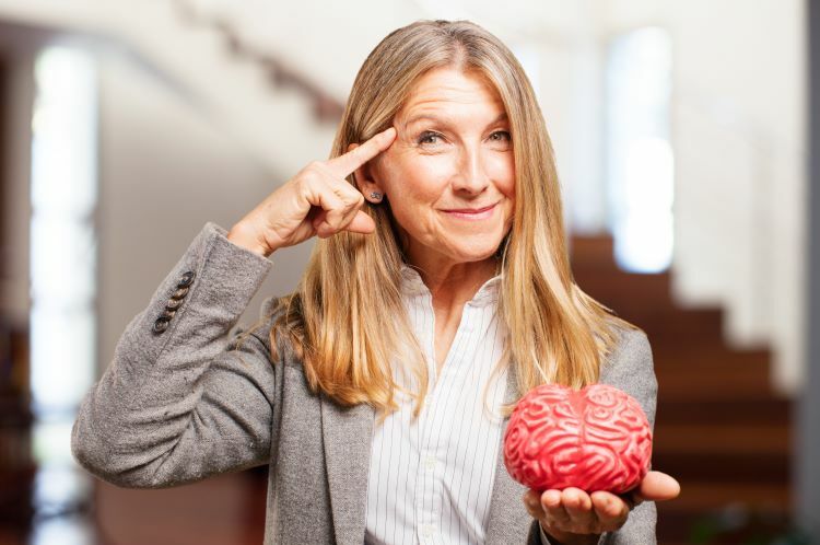 Frau 45+ hat Modell von Gehirn in Hand